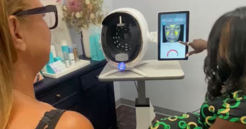 Dr. Kerline Marcelin walking a patient through her AI skin scan results on screen during a consultation