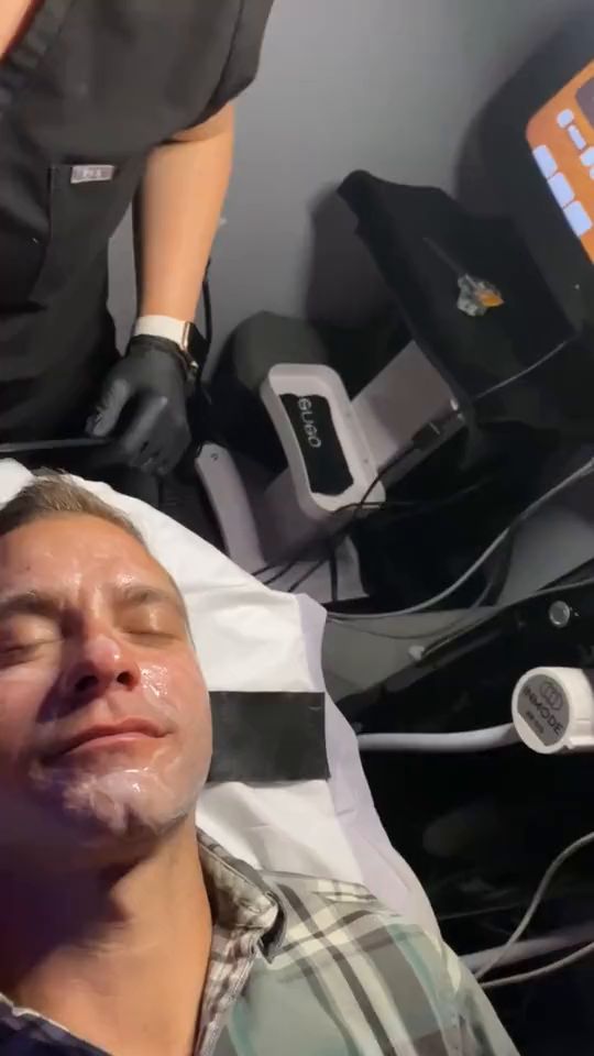 A Glo2Facial handpiece gliding across a patient’s cheek during an oxygenating facial