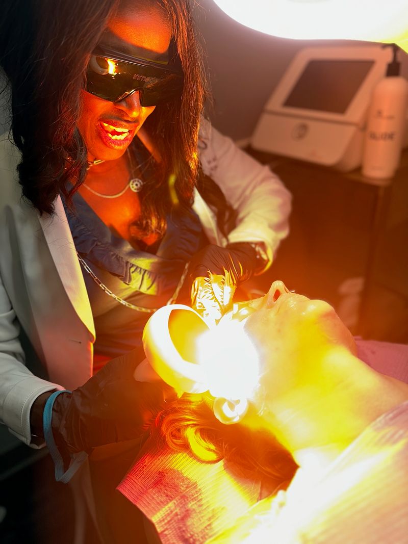 A patient in protective goggles during a Lumecca IPL photofacial, the handpiece against her cheek
